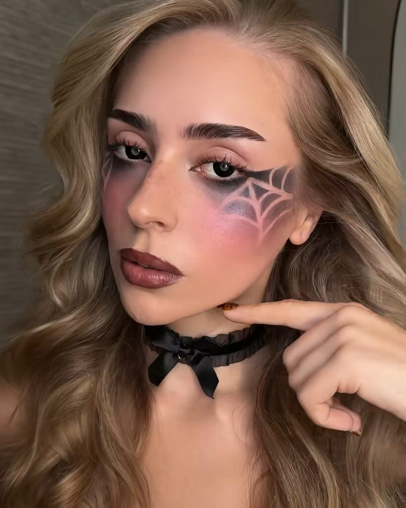Finished reverse spiderweb Halloween makeup with a berry lip and black choker