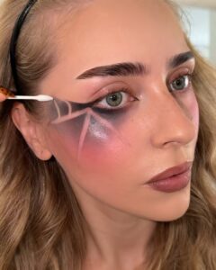 Swiping web lines through black eyeshadow with a cotton bud dipped in micellar water